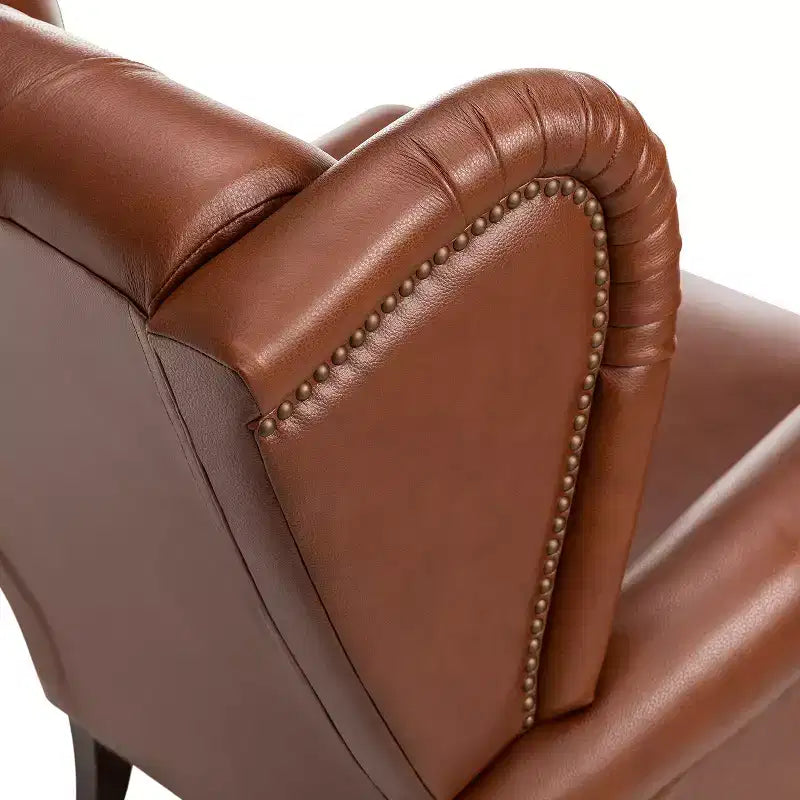 Poltrona a pozzetto larga 84 cm in vera pelle con gambe coniche in legno massello e bordo con borchie