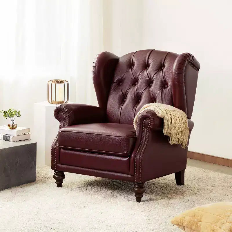 Poltrona a pozzetto larga 84 cm in vera pelle con gambe coniche in legno massello e bordo con borchie