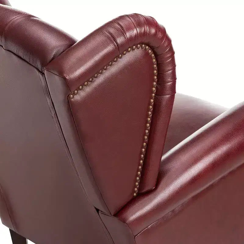 Poltrona a pozzetto larga 84 cm in vera pelle con gambe coniche in legno massello e bordo con borchie