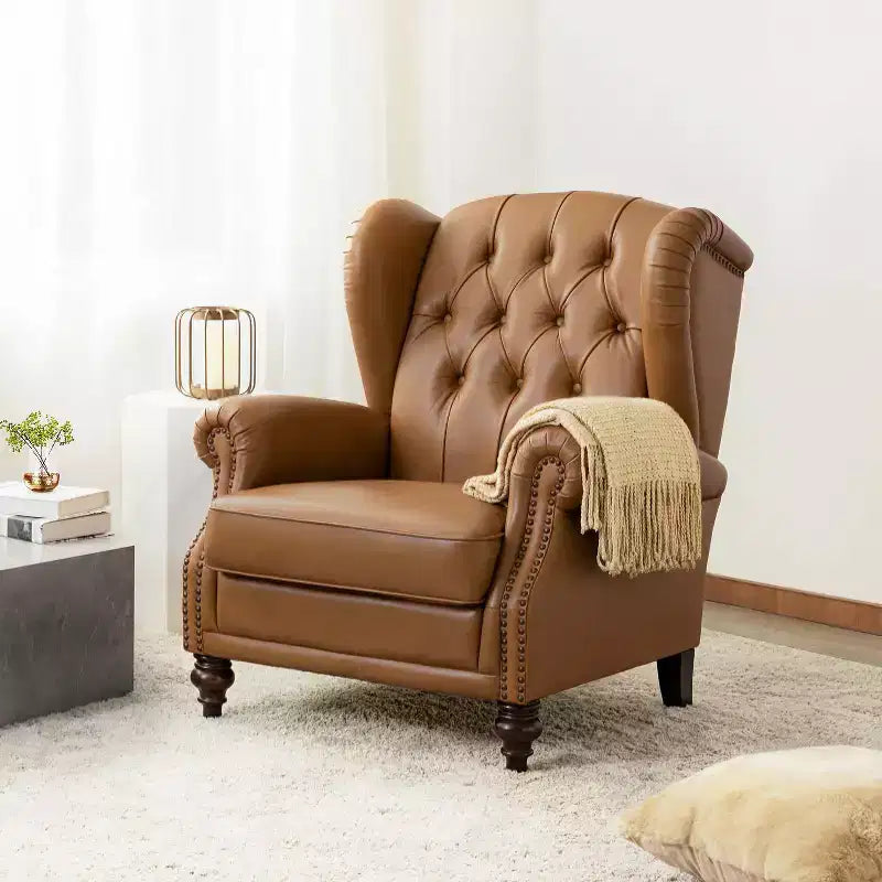 Poltrona a pozzetto larga 84 cm in vera pelle con gambe coniche in legno massello e bordo con borchie